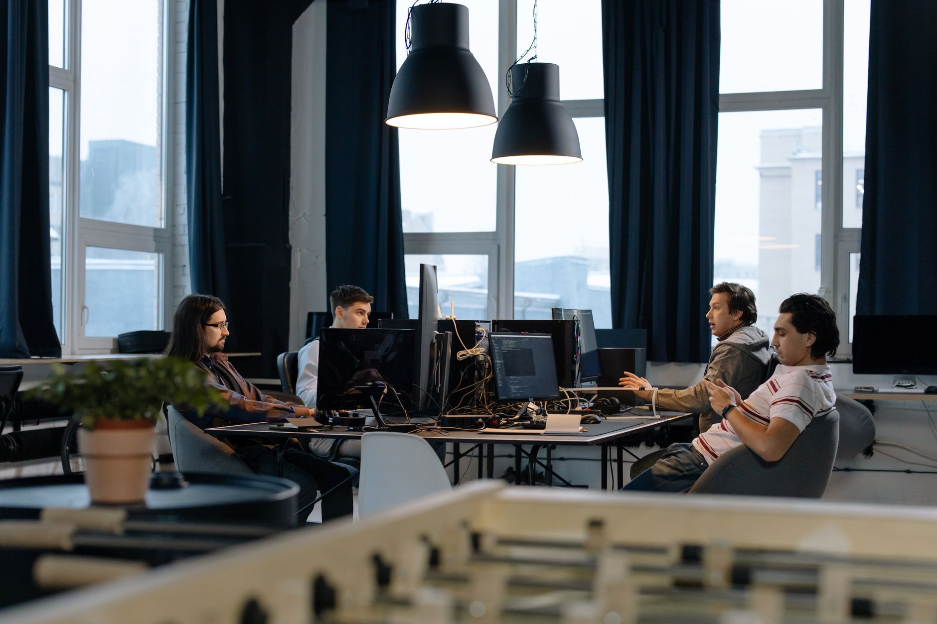 Des travailleurs collaborent dans un bureau moderne avec des ordinateurs, démontrant le travail d'équipe dans le développement technologique.